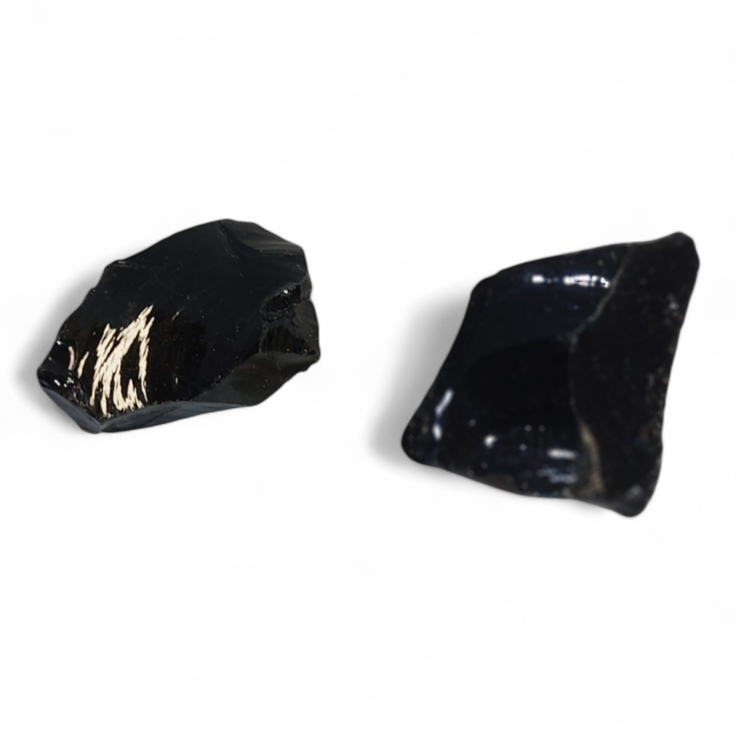 Obsidiana en bruto sobre fondo blanco, piedra volcánica negra para protección energética y limpieza emocional profunda