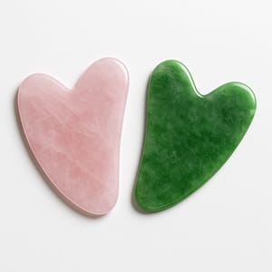 Gua Sha de minerales naturales: amatista, cuarzo rosa, jade y turquenita sobre fondo espiritual