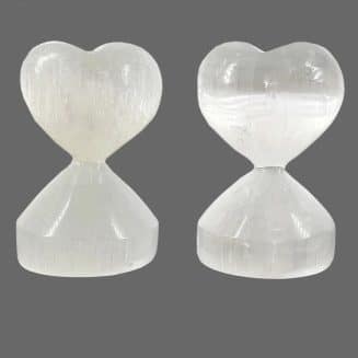 Corazón con base tallado completamente en selenita blanca, brillo perlado sobre fondo blanco, ideal para decoración espiritual