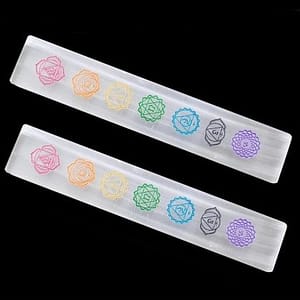 Tabla rectangular de selenita blanca con símbolos de los 7 chakras grabados sobre fondo blanco, ideal para recargar cristales