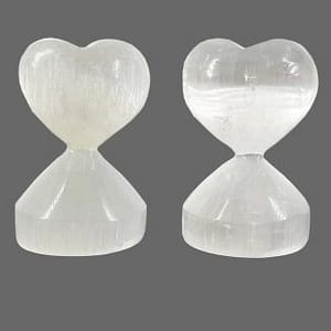 Corazón con base tallado completamente en selenita blanca, brillo perlado sobre fondo blanco, ideal para decoración espiritual